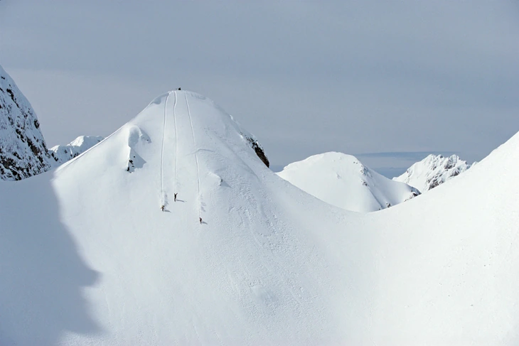 Skiers ascending a pristine alpine ridge photographed by Mark Gallup