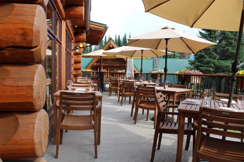 Outdoor dining tables and umbrellas on the Tamarack Lodge patio.