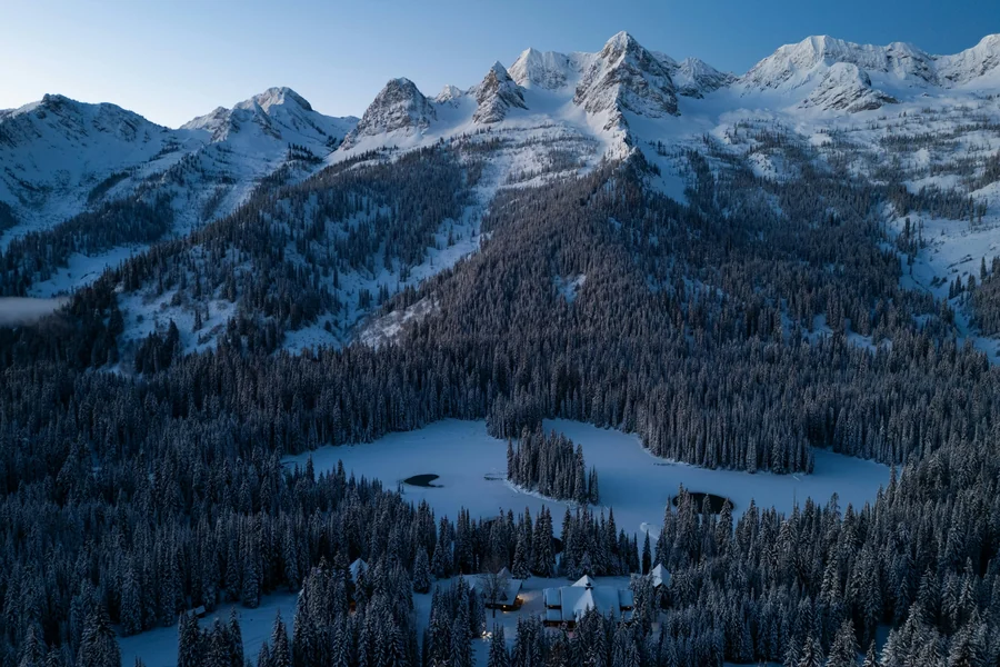 Snow-covered peaks of the Lizard Range above Island Lake and the forested valley