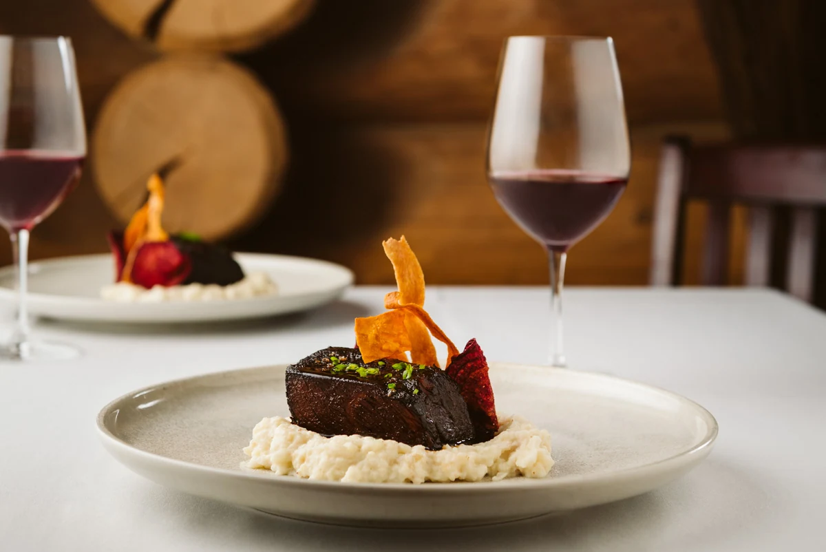A composed fine-dining plate served with red wine at Island Lake