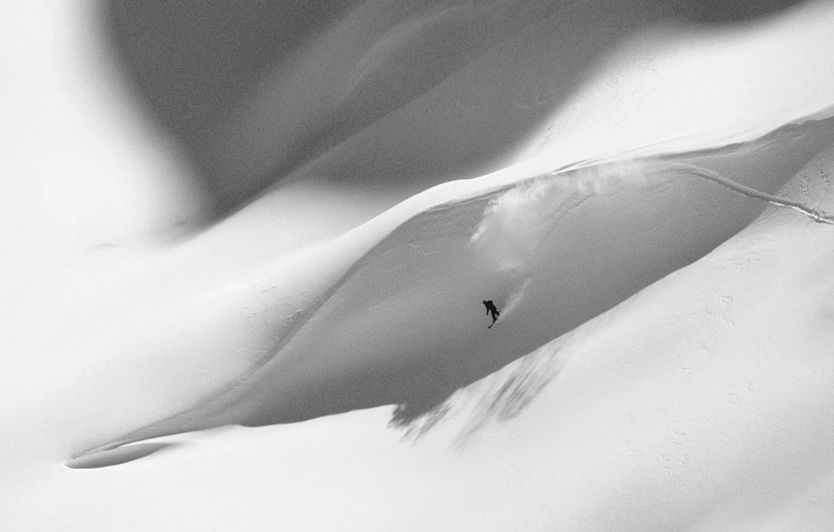 A rider descending an untracked powder bowl at Island Lake