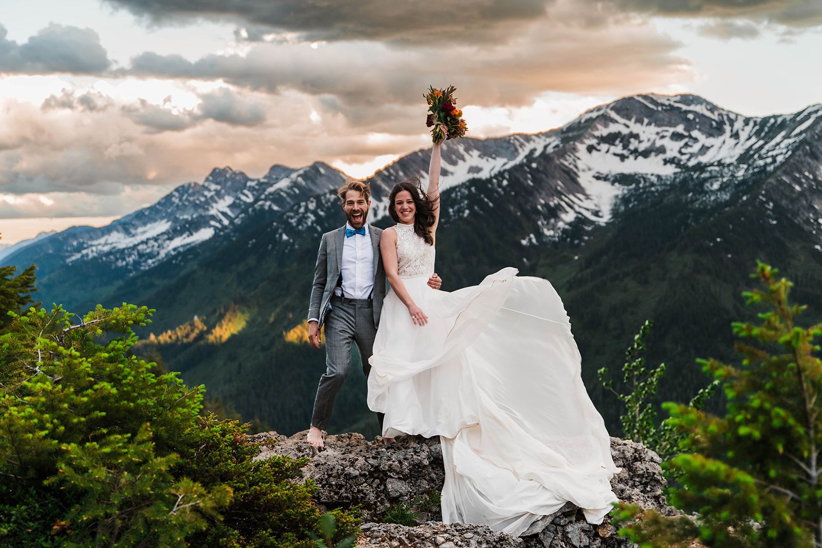 A newly married couple celebrating on a ridge above Island Lake